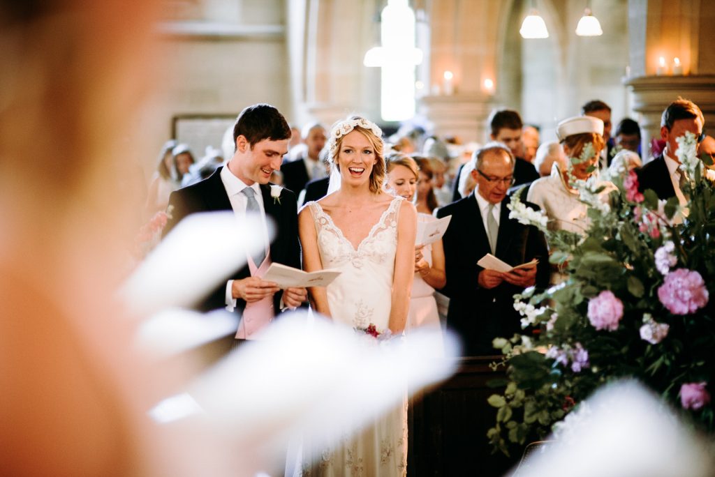 bride and groom singing hymes at st pauls catherdral london during thier wedding ceremony