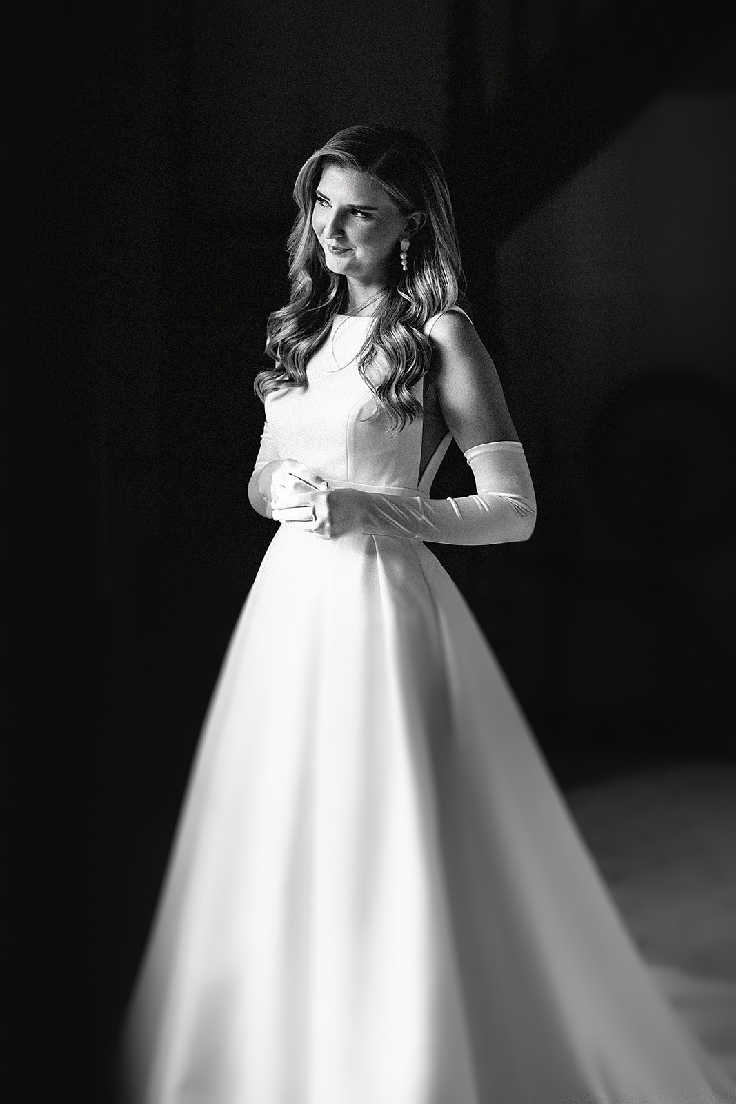 Black and white image of elegent bride by the window with light streeaming in on her face at Babbighton house in somerset.