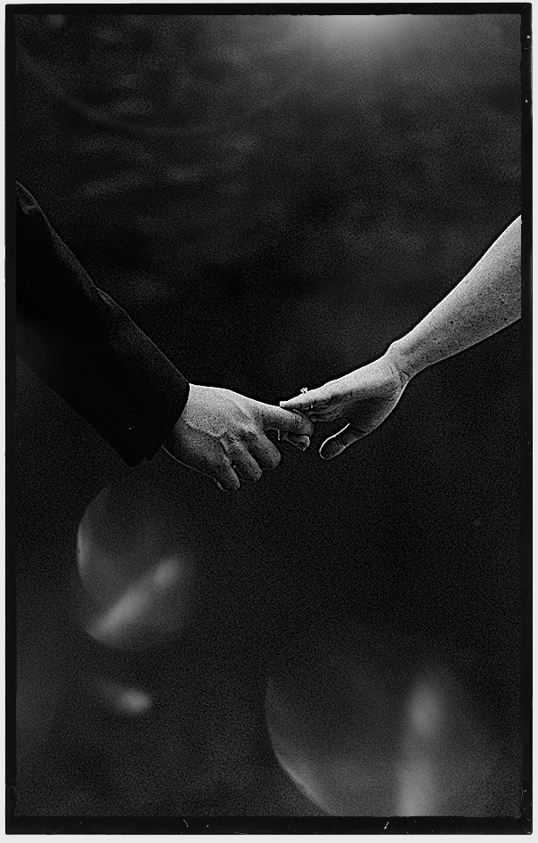 The wedding of Abbie & ken at The Equionx. - Andrew Brannan Photography Two hands grasping in a handshake, one wearing a dark sleeve and a ring on the other hand's finger, in black and white. Andrew Brannan Photography