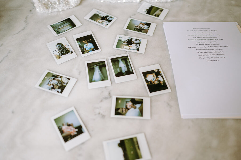 Assorted Polaroid photos scattered on a light marble surface beside a printed page with text Andrew Brannan Photography
