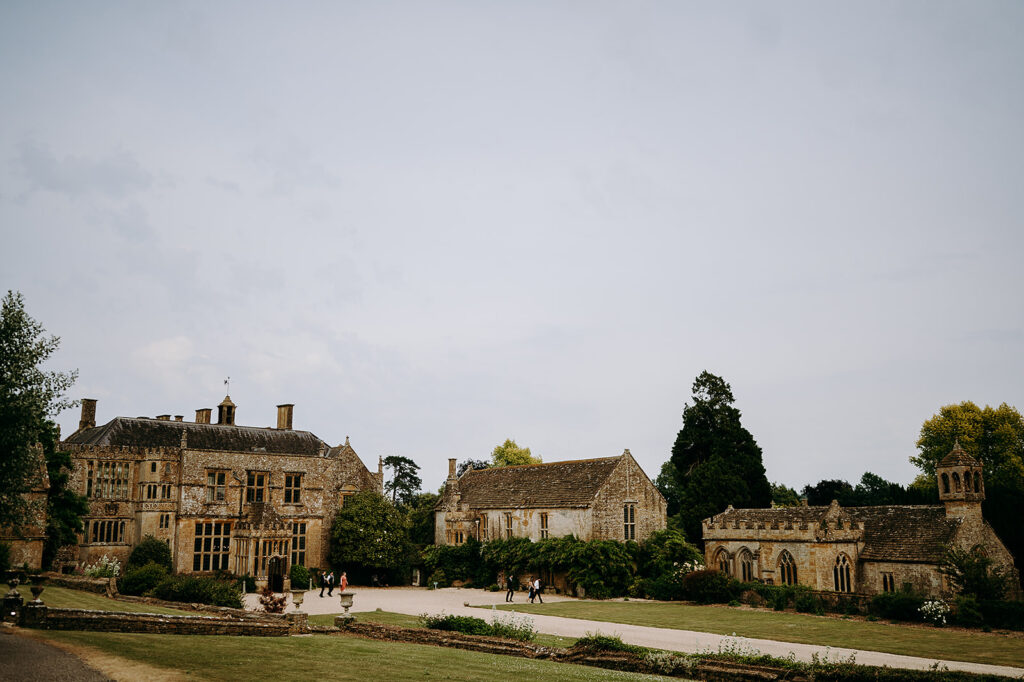 Historic stone estate with ivy-covered walls, gravel paths, and a few visitors strolling the courtyard at the front. Andrew Brannan Photography