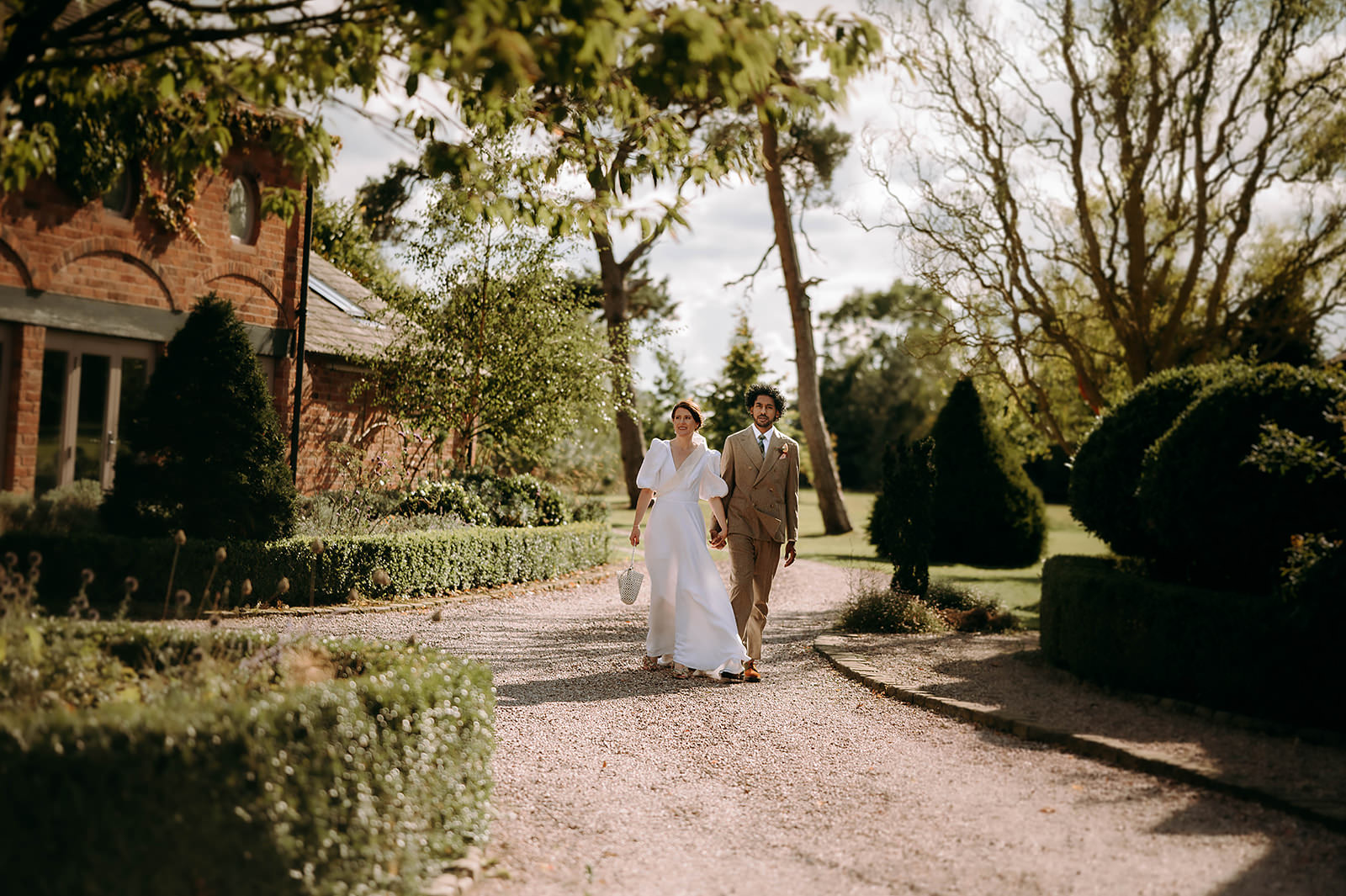 bride and groom walking hand in hand at scarlet hall in chesire uk
